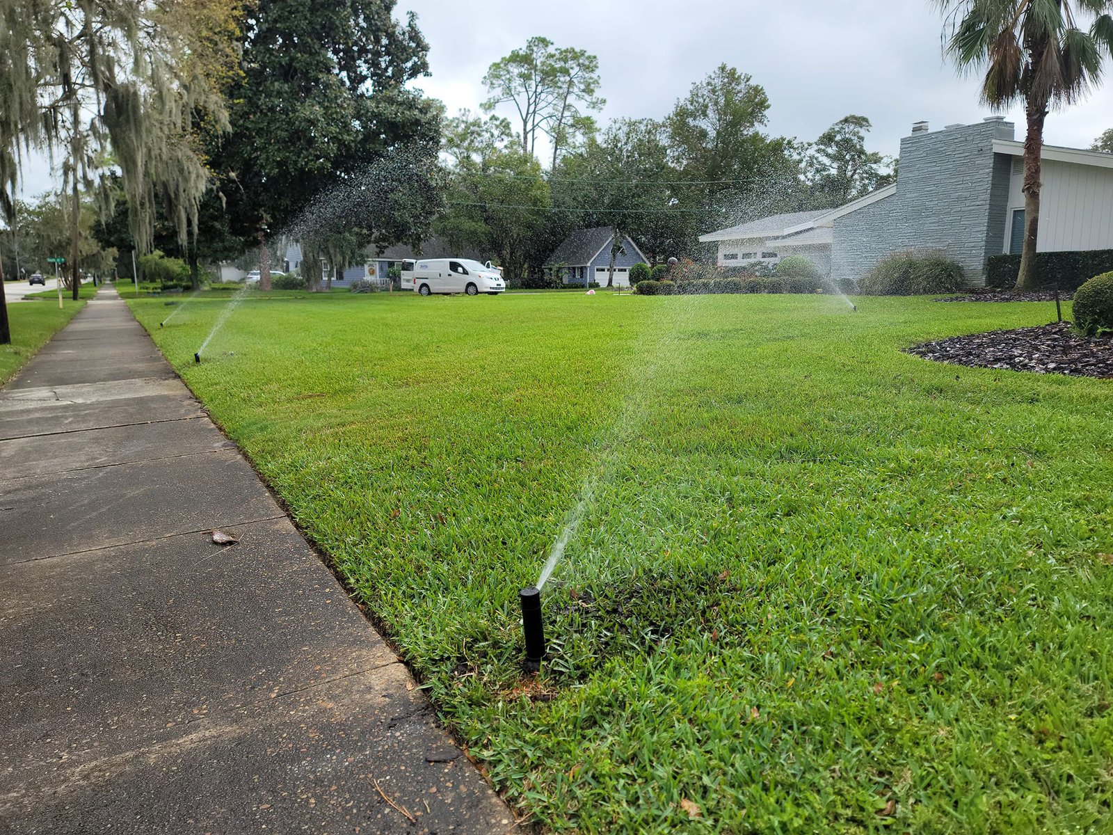 Sprinkler running in the yard of a family.